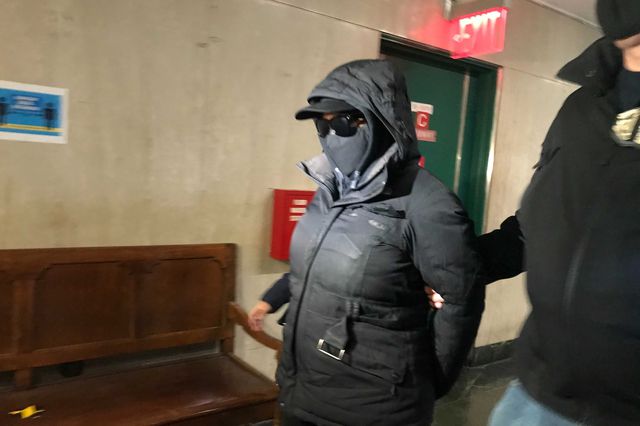 Captain Rebecca Hillman, her face obscured by a mask and sunglasses, appearing in court for her arraignment.